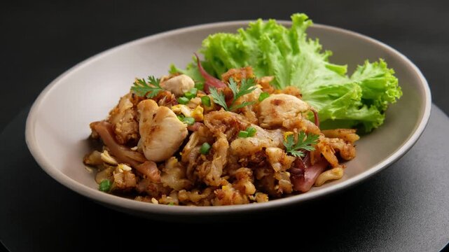 Stir fried Rice Noodles with Chicken.stir fry flat noodles with chicken ,Pickled squid and egg in a plate. (Kuay Teow Kua Gai)