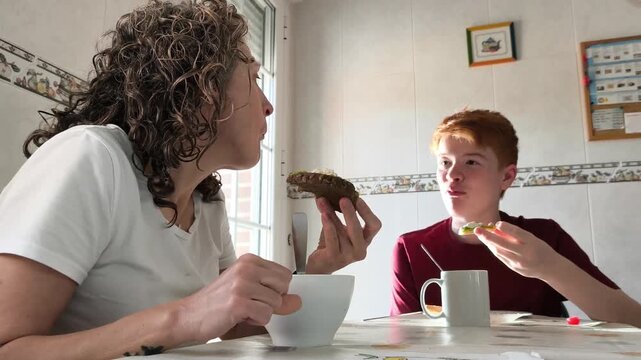 Mother and son sharing breakfast and conversation at home in modern family lifestyle