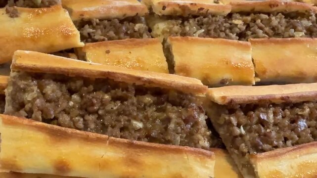 Turkish pide with ground meat filling arranged in rows, suitable for background use