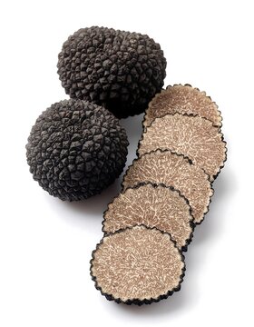 Fresh black truffles whole and sliced on white background.