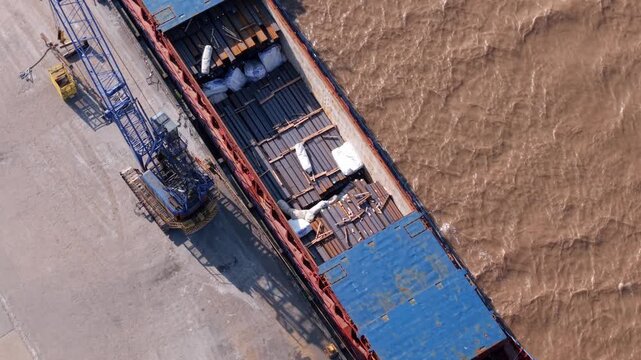 Aerial view of a cargo ship loaded with steel beams at PD Ports with a crane on the dock in Scunthorpe, England, United Kingdom.
