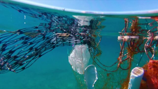 The image captures a serene coastal landscape marred by plastic pollution, with floating debris and garbage entangled in fishing nets.