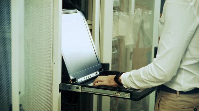 IT Engineer Working Console in Server Room. System Administrator Monitoring Database. Digital Technology Maintenance 