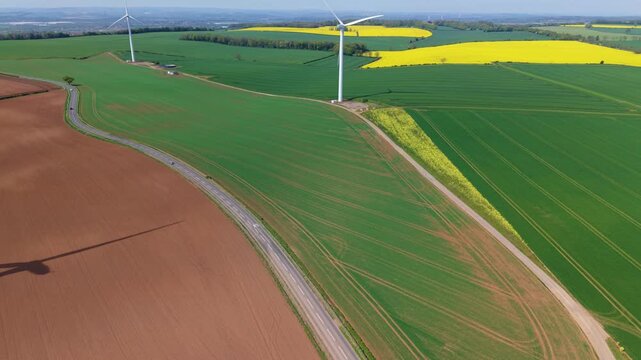 Aerial view of Marr Wind Farm featuring wind turbines standing over green and brown agricultural fields with a yellow rapeseed field in the distance Marr, England, United Kingdom.