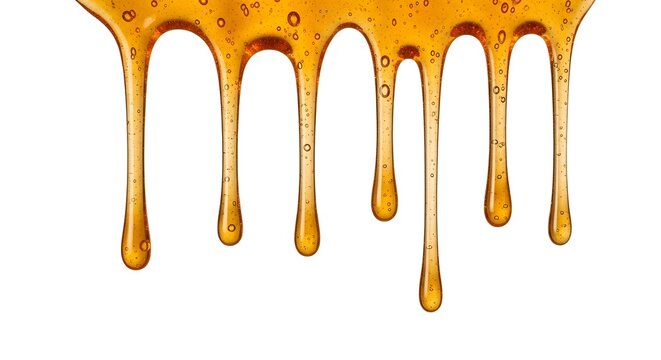 A close-up view of golden honey dripping down with bubbles on a white background