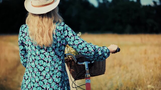 Woman Walking with Vintage Bicycle through Wheat Field. Rural Adventure and Nature Exploration. Peaceful Weekend in Village