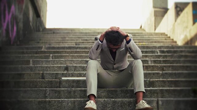Depressed Businessman Sitting on Concrete Stairs. Frustrated Office Worker in Despair During Work Break
