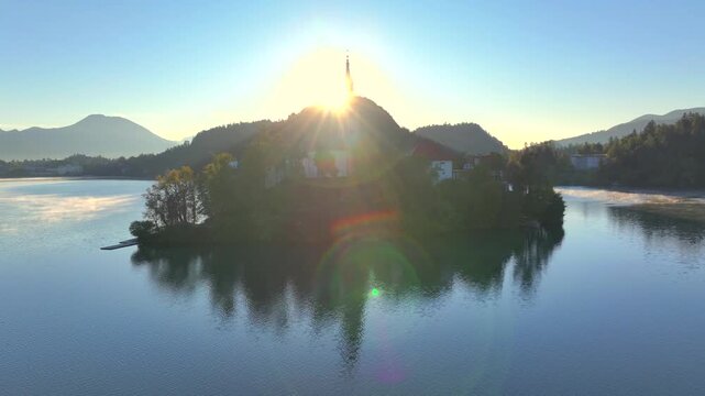 Aerial view of Lake Bled at sunrise in autumn, Slovenia. Pilgrimage Church on island and medieval Bled Castle on a cliff