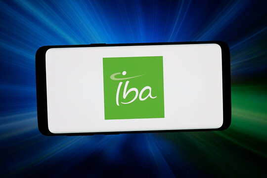 Stuttgart, Germany - 04-28-2026: In this photo illustration, the logo of company Ion Beam Applications S.A. (IBA) is displayed on a smartphone in front of abstract background on computer screen.
