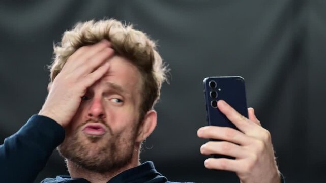 Social media culture, man looking at his phone with array of emotions, close up on the face isolated portrait shot, real time video authentic, white people. Posing for social media, modern influence c