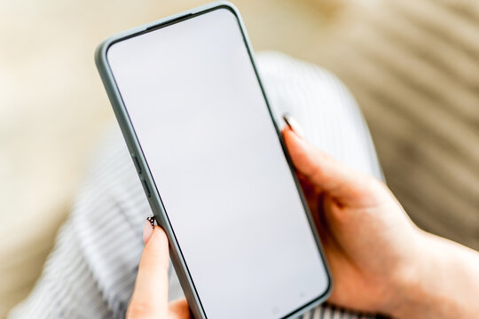 Girl On Sofa Holding Smartphone With White Screen