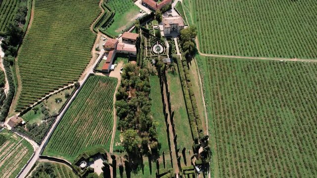 Manicured lawns and symmetrical landscape features. Historic estate with formal hedges and central water feature