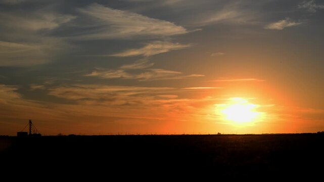 A tranquil sunset over a rural, flat landscape, likely a wheatbelt or prairie region. Amarillo, Texas
