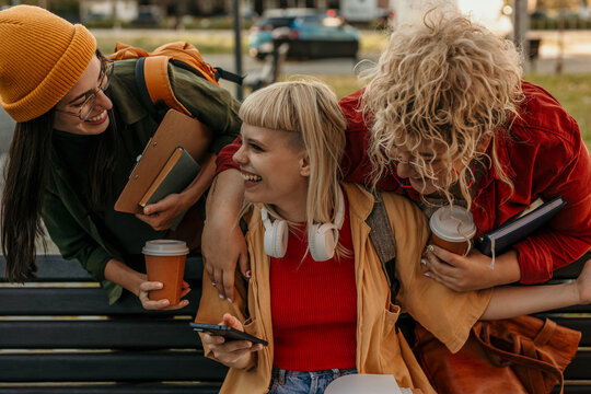 Young student friends relaxing outdoors after university classes
