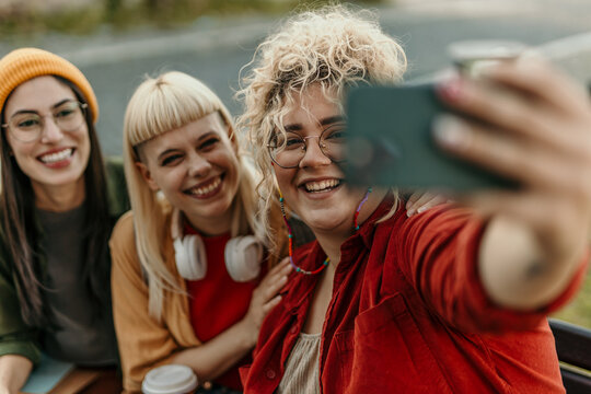 Diverse young friends taking selfie sharing happiness outdoors