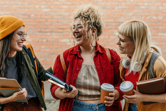 Happy diverse students laughing together on campus