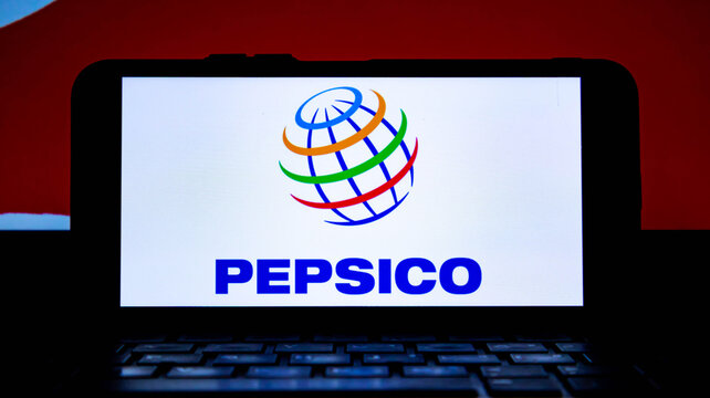 Pepsico logo and branding displayed on a smartphone screen placed on a laptop keyboard against a red background