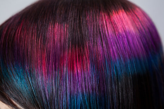 Extreme closeup of pixelated hair color pattern showing detailed strands with pink blue hues posing isolated over gray background