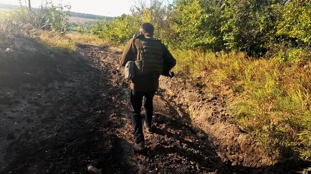 Volunteers in protective uniform jogging on dirty country road at frontline city in Ukraine. Rescue workers running to help animals and people from areas shelled by russian army. Slow motion