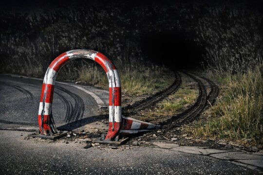 A red and white barricade placed on the side of a road, ideal for use in scenes related to construction, traffic management or road closure