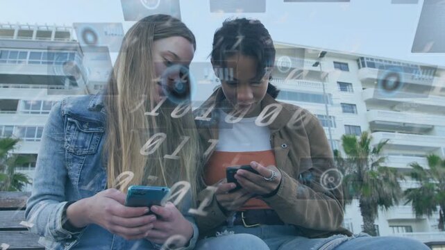 Two girls sitting on coast seat right girl tapping phone, sharing content, tech overlay over phones