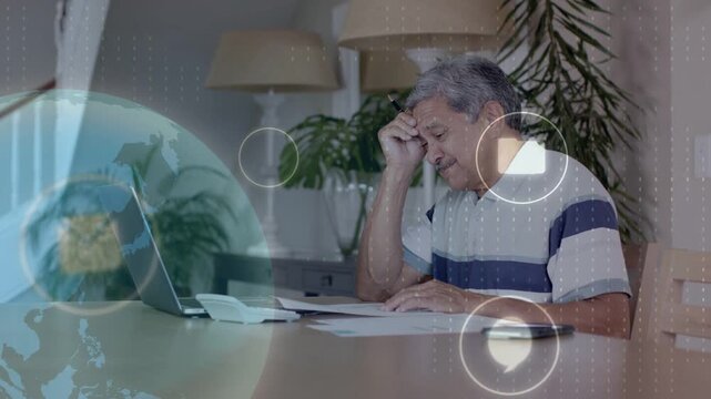 Sr man reading papers rubbing head noting bills using laptop globe icons moving on laptop finance