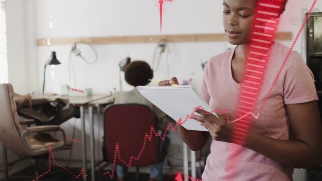 Woman jotting on pad in office, red graphs sweeping and aligning with pad for business insight