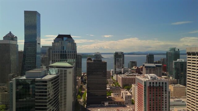 Drone flying through Seattle high rise buildings with waterfront skyline