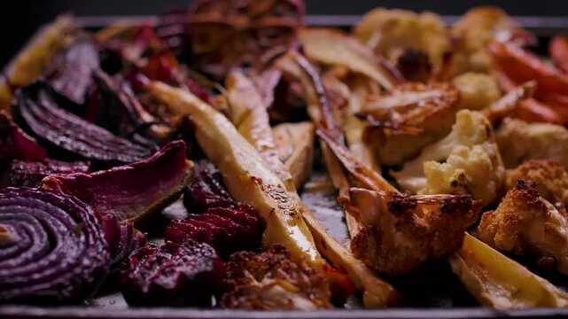 Panorama of appetizing roasted vegetables for Sunday roast. Close up of beetroot parsnip and carrot. Healthy homemade family dinner food.