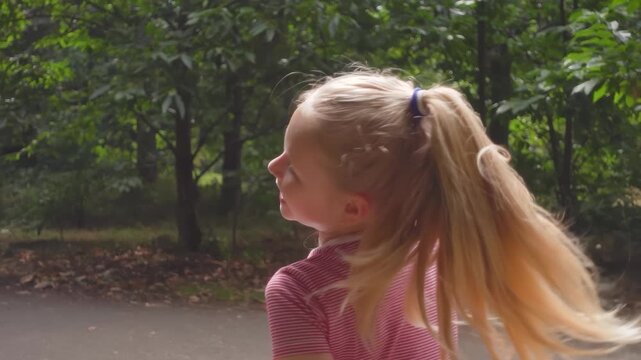 A beautiful fair haired girl turning around tossing her hair back. Playful cheerful smiling happily.