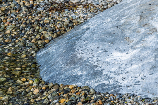 Texture d&eacute;taill&eacute;e d'un bloc erratique mill&eacute;naire sur une plage de Saint-Prex au bord du lac L&eacute;man, Suisse