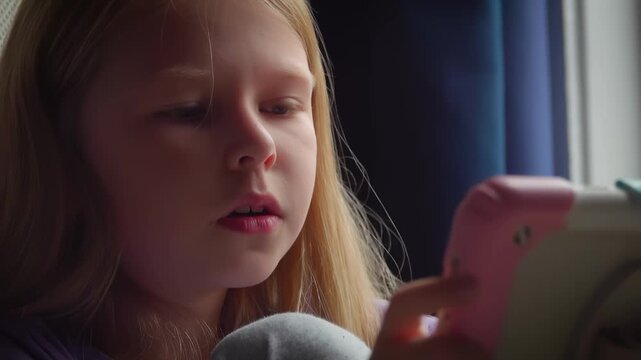 A girl holds a tablet. She watches its screen with interest but becomes confused by some results. Close up shot. Mixed emotions of curiosity and bewilderment