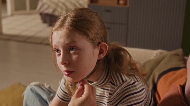 Close up shot of preteen girl sharing feelings with mother while woman gently tucking daughters hair behind ear during trusting conversation in living room