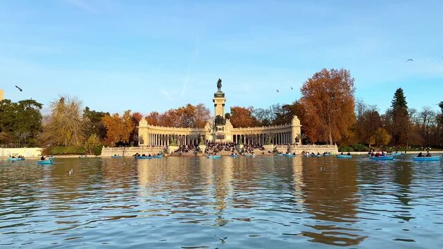 Landscape of the Retiro Park in Madrid, with the monument to King Alfonso XII and boats on the lake
