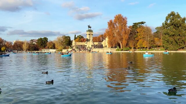 Landscape of the Retiro Park in Madrid, with the monument to King Alfonso XII and boats on the lake