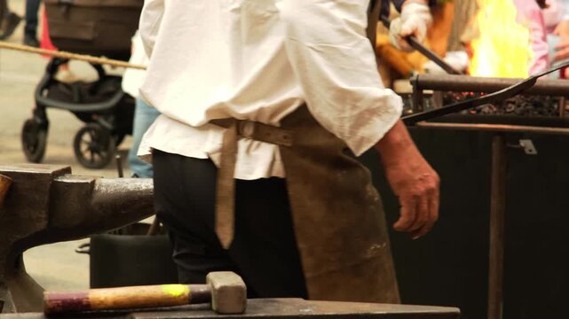 Blacksmith forging iron with a hammer and anvil