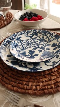 Table setting video with blue floral plates and fresh berry bowl. Warm home dining scene with elegant tableware and soft natural light. Cozy lifestyle montage for serving, decor, and everyday meal