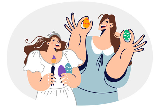 Mom and daughter decorate easter eggs, preparing for orthodox holiday, and hold brushes in hands