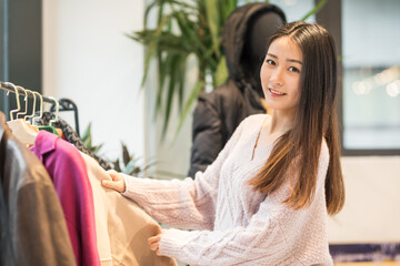 Obraz premium Smiling young woman shopping for clothes in boutique