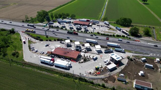 Highway Rest Stop Panorama: An aerial view showcases a bustling highway rest stop, complete with fuel stations, dining facilities, and ample parking for trucks and cars.