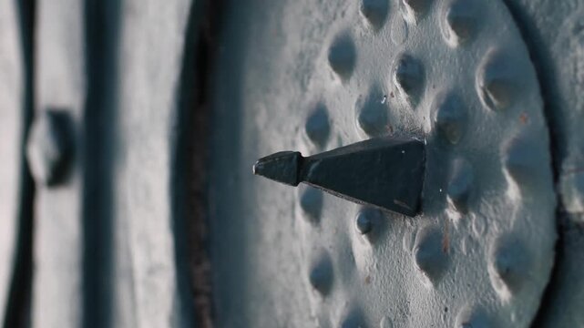 steel shield with a sharp spike is nailed to the gate of an ancient fortress zoom out