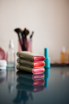 Set of cosmetic products with blush in sticks on table close up. Make up collection with brushes.