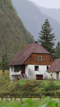 car driving in the rain past a small house in the soca river valley of slovenia (europe european travel tourism destination) julian alps  motor vehicle automobile