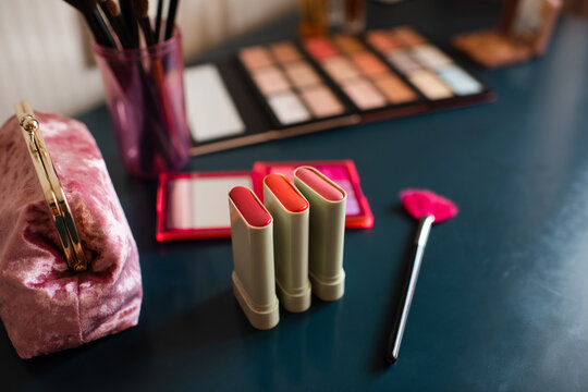 Set of cosmetic products with blush in sticks on table close up. Make up collection.