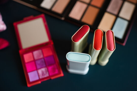 Set of cosmetic products with blush in sticks on table close up. Make up collection.