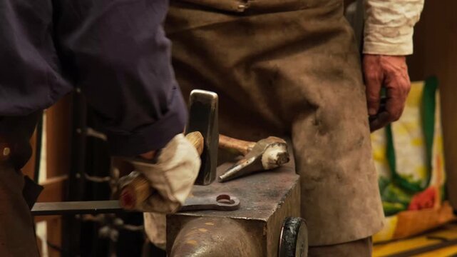 Blacksmith forging iron with a hammer and anvil