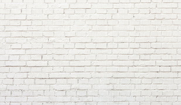 A textured white brick wall with a uniform appearance. The bricks are arranged in a traditional pattern, giving the wall a clean and minimalistic look.