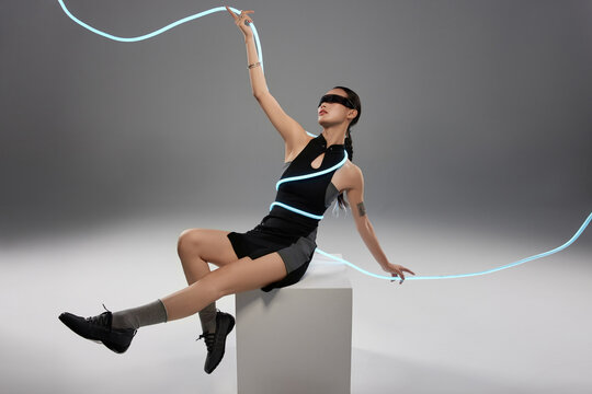 Futuristic Woman Posing with Glowing Blue Rope