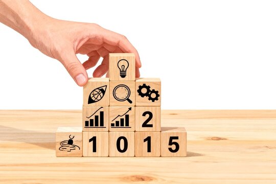 Hand placing wooden blocks with icons and numbers