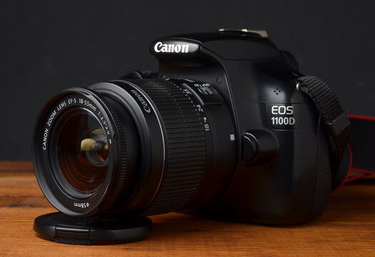PERPIGNAN, FRANCE - MAY 7, 2026: A Canon EOS 1100D DSLR camera equipped with a 18-55mm kit lens on a wooden tabletop. An entry-level digital photography setup for beginners and hobbyists.